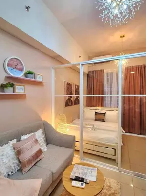 a living room with a couch and a bedroom at Payapa Staycation by DC in Manila