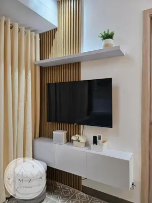 a living room with a television on a wall at MZ Suite Home at SMDC Charm Residences in Manila