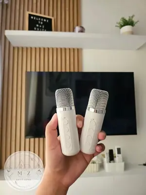 a person holding two microphones in front of a tv at MZ Suite Home at SMDC Charm Residences in Manila