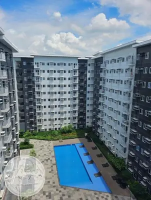 a large apartment building with a swimming pool in the middle at MZ Suite Home at SMDC Charm Residences in Manila