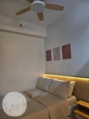 a bedroom with a bed with a ceiling fan at MZ Suite Home at SMDC Charm Residences in Manila