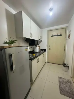 a kitchen with white cabinets and a refrigerator and a door at Makati Jazz Staycation in Manila