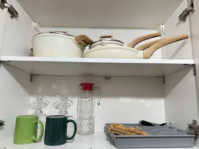 a shelf with cups and utensils in a kitchen at Makati Jazz Staycation in Manila