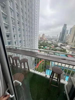 a balcony with two stools and a view of a city at Makati Jazz Staycation in Manila