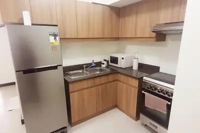 a kitchen with a stainless steel refrigerator and a sink at Helaena's Scandi Haven in Manila