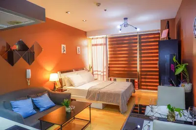 a bedroom with a bed and a couch in a room at Studio in Makati - Fast WiFi, Big Balcony, Pool and Gym Access in Manila