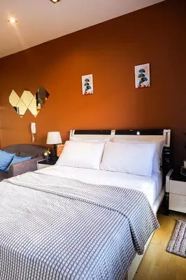 a bedroom with a large bed with a striped blanket at Studio in Makati - Fast WiFi, Big Balcony, Pool and Gym Access in Manila