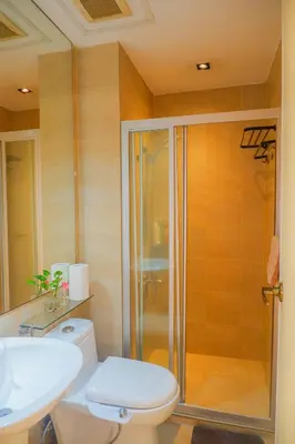 a bathroom with a shower and a toilet and a sink at Studio in Makati - Fast WiFi, Big Balcony, Pool and Gym Access in Manila