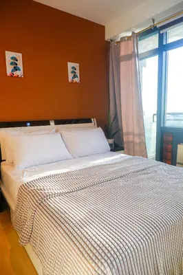 a bedroom with a bed with a striped comforter at Studio in Makati - Fast WiFi, Big Balcony, Pool and Gym Access in Manila