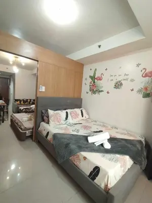 a bedroom with two beds and a mirror at Staycation In front of Mall of Asia Triple M in Manila