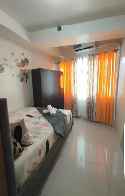 a bedroom with a bed and a window with curtains at Staycation In front of Mall of Asia Triple M in Manila
