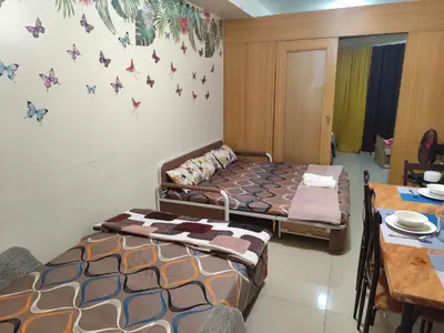 two beds in a room with butterflies on the wall at Staycation In front of Mall of Asia Triple M in Manila