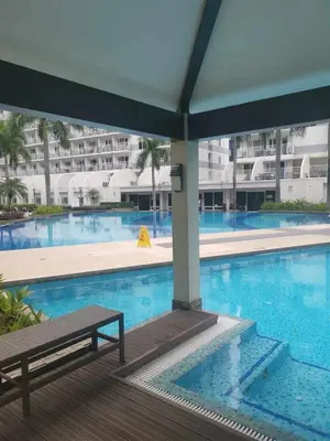 a swimming pool with a bench next to a building at Staycation In front of Mall of Asia Triple M in Manila