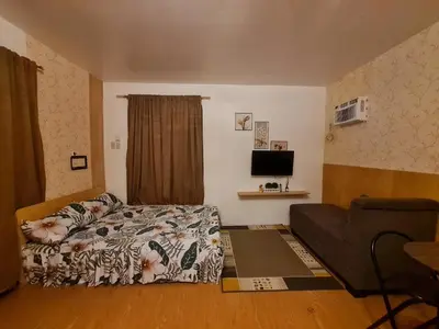 a bedroom with a bed and a couch in it at Studio-type Home in Trece Martires near Tagaytay in Trece Martires