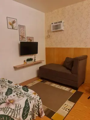 a living room with a couch and a flat screen tv at Studio-type Home in Trece Martires near Tagaytay in Trece Martires