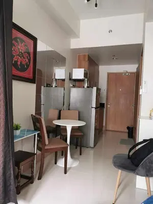 a kitchen and living room with a table and chairs at Mall of Asia Pasay Shore 3 residences 2 in Manila