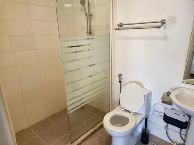 a bathroom with a shower and a toilet and a sink at Elegant Family Retreat in the Heart of BGC in Manila