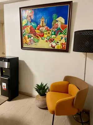 a living room with a painting of fruits on the wall at Elegant Family Retreat in the Heart of BGC in Manila
