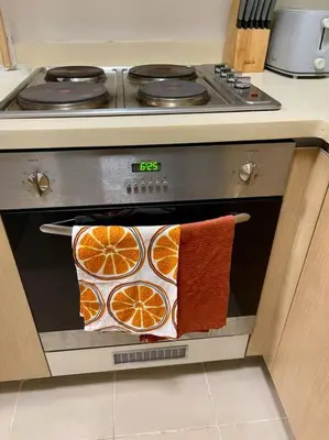 an oven with towels on the door of a stove at Elegant Family Retreat in the Heart of BGC in Manila