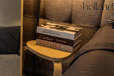 a stack of books sitting on a table next to a bed at Mall of Asia Shore 3 Residences Holland Suites in Manila