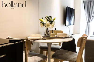 a dining room with a table with flowers and a tv at Mall of Asia Shore 3 Residences Holland Suites in Manila