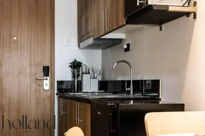 a kitchen with a sink and wooden cabinets at Mall of Asia Shore 3 Residences Holland Suites in Manila