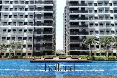 a hotel sign in front of two tall buildings at Mall of Asia Shore 3 Residences Holland Suites in Manila