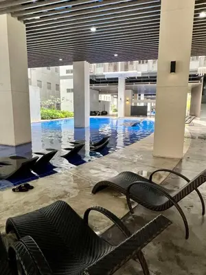 a lobby with a swimming pool in a building at Comfortable and Cozy 1BR unit near MOA in Manila