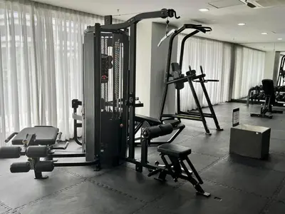 a gym with several tread machines in a room at Comfortable and Cozy 1BR unit near MOA in Manila