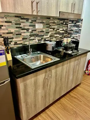a kitchen with a sink and a counter top at Comfortable and Cozy 1BR unit near MOA in Manila