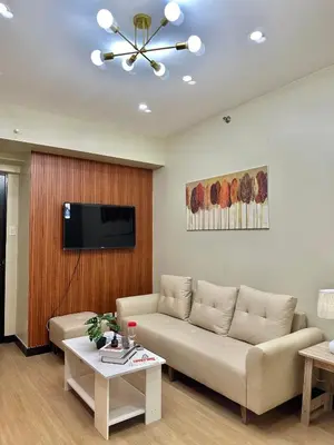 a living room with a couch and a flat screen tv at Fully Furnished One Bedroom Unit with Balcony at Calathea Place, DMCI Homes in Manila