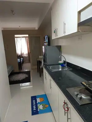 a kitchen with a sink and a counter top at Mall of Asia Sea Residences AMY'S Staycation in Manila