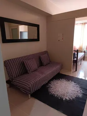 a living room with a couch and a mirror at Mall of Asia Sea Residences AMY'S Staycation in Manila