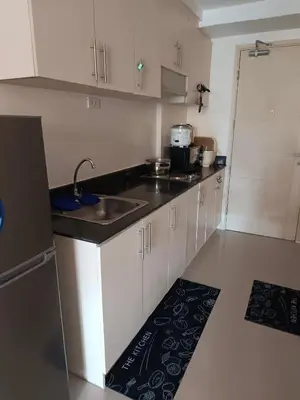 a kitchen with white cabinets and a sink at Mall of Asia Sea Residences AMY'S Staycation in Manila