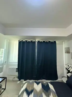 a bedroom with a blue curtain in a room at Casita Payapa - newly furnished condo unit 2nd flr in Manila