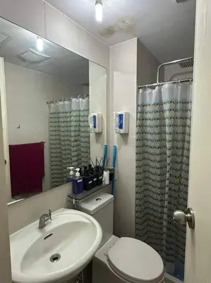a bathroom with a sink and a toilet and a mirror at Casita Payapa - newly furnished condo unit 2nd flr in Manila