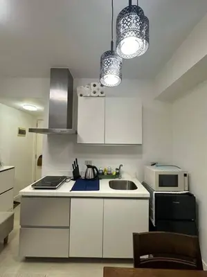 a white kitchen with a sink and a microwave at Casita Payapa - newly furnished condo unit 2nd flr in Manila