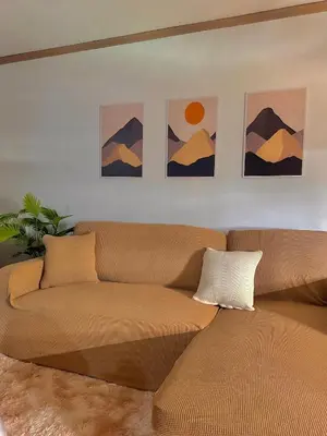 a couch in a living room with paintings on the wall at Vibin Chill Staycation in Manila