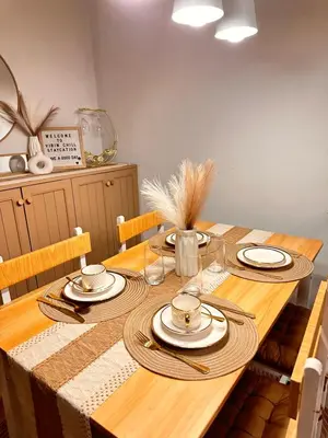 a wooden table with plates and utensils on it at Vibin Chill Staycation in Manila
