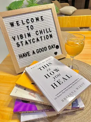 a welcome sign and a glass of orange juice on a table at Vibin Chill Staycation in Manila