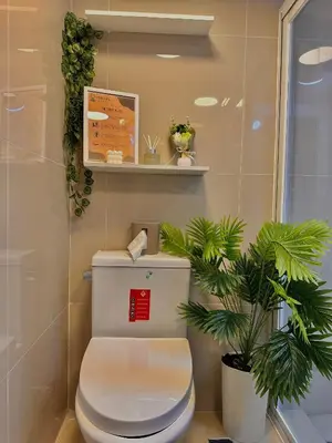 a bathroom with a toilet and a plant at Vibin Chill Staycation in Manila