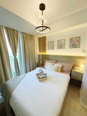 a bedroom with a large white bed and a window at Casa Marix & Z - City View Unit in Manila