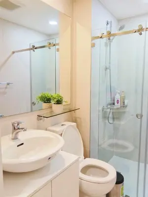 a bathroom with a toilet and a sink and a shower at Casa Marix & Z - City View Unit in Manila