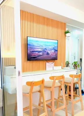 a dining room with a table and a tv on a wall at Casa Marix & Z - City View Unit in Manila