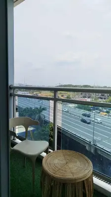 a table and chair on a balcony with a view of a highway at Casa Marix & Z - City View Unit in Manila