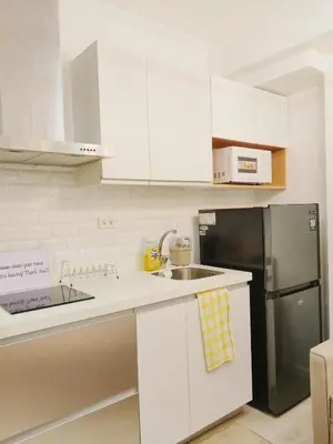 a kitchen with white cabinets and a black refrigerator at Casa Marix & Z - City View Unit in Manila