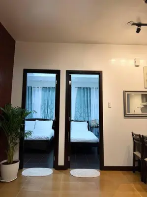 a room with two beds and two glass doors at Ram's crib at san lorenzo's place condo in Manila