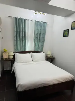 a bedroom with a white bed with a window at Ram's crib at san lorenzo's place condo in Manila