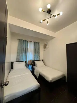 a room with two beds and a window at Ram's crib at san lorenzo's place condo in Manila
