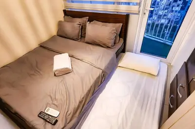 a small bed in a room with a window at Boho Beach Vibes 2br Apt 2 in Makati in Manila